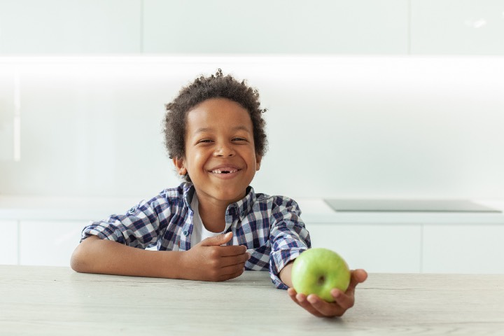 Little child boy with green apple