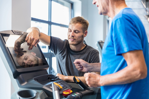 Man on treadmill with personal trainer