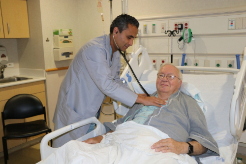 Dr. Demo checking Anderson's breathing