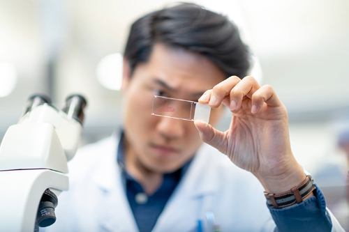 Man looking at microscope test